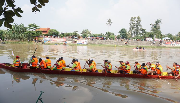Para peserta Lomba perahu Naga sedang mendayung perahunya