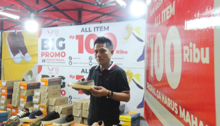 Seorang pedagang sepatu Hagamo sedang menunjukan sepatu produk lokal buatan sendiri di acara Pesta Rakyat Tangerang Mall Balekota Kota Tangerang. Jumat (27/1/24). potretbanten /Leoni