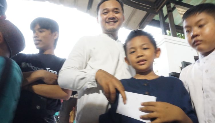 Ikhwan Adi Putra selaku wakil ketua dari Komunitas Remaja Bangor Tangerang Raya memberikan amplop santunan ke anak yatim